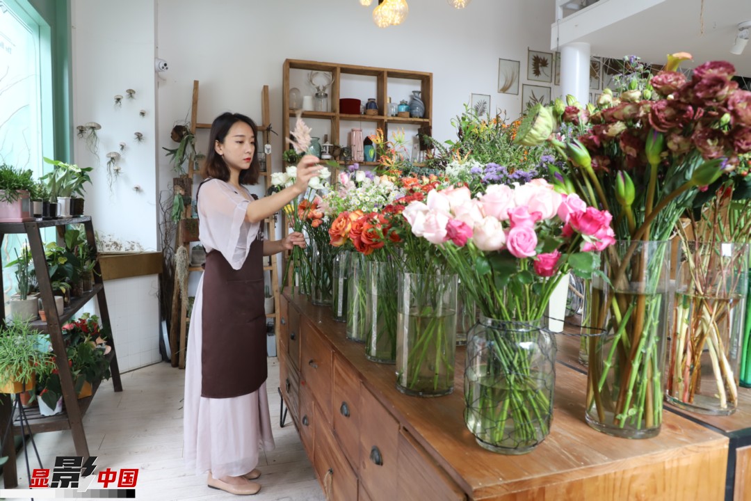 王黎媛是一名河南姑娘，在昆明念完大學(xué)后，就再也舍不下春城的藍(lán)天陽(yáng)光、青山碧水，更舍不下這里的四時(shí)繁花，于是就干脆留了下來(lái)，成了一名媒體人。2017年的時(shí)候又毅然辭去工作，創(chuàng)業(yè)開起了花店，成了都市里的一名“花房姑娘”。圖為王黎媛在自己的花店中整理鮮花。新華網(wǎng) 周亞平/攝 念新洪/文